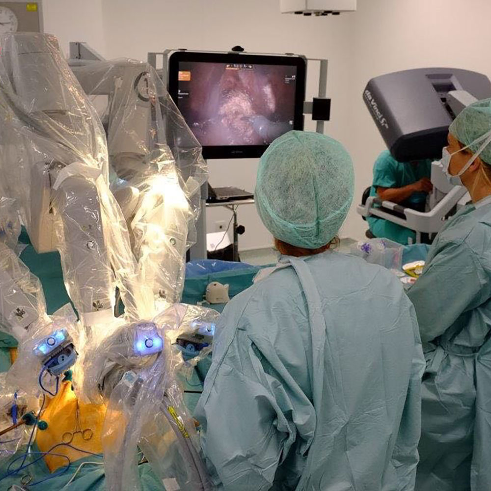 A surgical assistant working alongside robotic instruments.